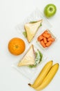 top view of fruits and sandwiches in ziplock bags