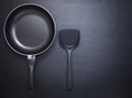 Top view frying pan and plastic spade on black table background. Royalty Free Stock Photo