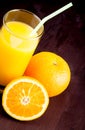 Top of view of full glass of orange juice with straw near fruit orange Royalty Free Stock Photo