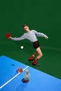 Top view. Funny creative photo with man un shirt and underweared playing table tennis with whiskey glass over green