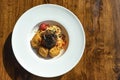 Top view of fusion spaghetti topped with ebiko and seaweed Attached with fried breaded meat. in a white round plate on a wooden Royalty Free Stock Photo