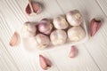 Top view garlic heads in a plastic container on a white wooden table