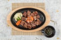 Top view of Garlic Saikoro Steak: medium rare dice wagyu topping with mince carrot on hot plate served with potato salad. Royalty Free Stock Photo