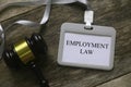 Top view of gavel and a lanyard with card holder written with Employment Law on wooden background