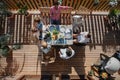 Top view of 3 generations family eating at barbecue party dinner on patio, people sitting at table on patio with grill. Royalty Free Stock Photo