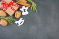 Top view of gift box with red christmas ribbon surrounded by spices and christmas ornaments