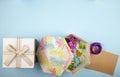 top view of a gift box tied with bow and a gift box filled with colorful chrysanthemum flowers with daisy and purple ribbon with