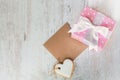 Top view of a gift box wrapped in pink dotted paper, heart shaped love cookie and an empty kraft card over a white wood background Royalty Free Stock Photo