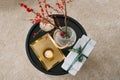 Top view of gift boxes tied with an emerald ribbon with a sprig of spruce, a candle, a vase of red berries and a gold tray. Lay fl Royalty Free Stock Photo