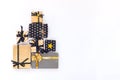 Top view of gift boxes in various black, white and golden designs arranged in triangular shape like Christmas tree or birthday cak