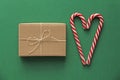 Top view. Gift Kraft Brown Color Box and Candy Canes Red and White in Heart Shape Lies on the Green Background, View From the Top Royalty Free Stock Photo
