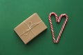 Top view. Gift Kraft Brown Color Box and Candy Canes Red and White in Heart Shape Lies on the Green Background, View From the Top Royalty Free Stock Photo