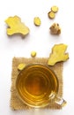Top view of ginger tea in a cup on sackcloth with a piece of sliced ginger on a white background. Herbal drinks ,alternative