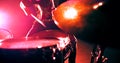 Top view of girl emphatically playing the drum kit in twinkling strobe lights