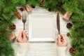 Top view girl holds fork and knife in hand and is ready to eat. Empty white square plate on wooden christmas background. holiday d Royalty Free Stock Photo