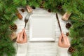Top view girl holds fork and knife in hand and is ready to eat. Empty white square plate on wooden christmas background. holiday d Royalty Free Stock Photo