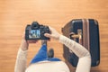 Top view on a girl looking a photos Chicago city on her camera standing with suitcase in the airport. The girl returns home after Royalty Free Stock Photo