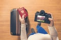 Top view on a girl looking a photos Flowering Sakura on her camera standing with suitcase in the airport. The girl returns home af Royalty Free Stock Photo