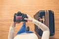 Top view on a girl looking a photos Flowering Sakura on her camera standing with suitcase in the airport. The girl returns home af Royalty Free Stock Photo