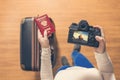 Top view on a girl looking a photos of fresh coconut juice on her camera standing with suitcase in the airport. The girl returns h Royalty Free Stock Photo