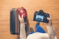 Top view on a girl looking a photos from New York city on her camera standing with suitcase in the airport. The girl returns home Royalty Free Stock Photo