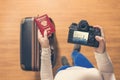 Top view on a girl looking a photos from New York city on her camera standing with suitcase in the airport. Royalty Free Stock Photo