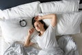 Top view of a girl sleeping next to an alarm clock. Time to wake up. On the wake-up clock 7 a.m. Deep sleep Royalty Free Stock Photo