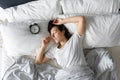 Top view of a girl sleeping next to an alarm clock. Time to wake up. On the wake-up clock 7 a.m. Deep sleep Royalty Free Stock Photo