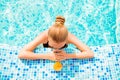 Top view of girl swimming in a pool with juice and glasses