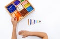 Top view of girls hand is sorting a puzzle of colored plastic beads in montessori school Royalty Free Stock Photo