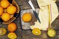 Top view of glass bottle of fresh orange juice with fresh fruits in basket and flowers vase on wooden planks table Royalty Free Stock Photo