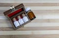 Top view of Glass Bottles of homeopathic pills in a wooden box on wood background