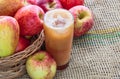 Top view of a glass of freshly squeezed apple juice with red ripe apples on the side juice