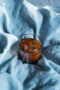 Top view of glass with ice coffee with vegan milk on blue linen blanket