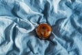 Top view of glass with ice coffee with vegan milk on blue linen blanket