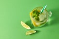 Refreshing homemade sparkling lemonade with ice in mason jar, slices of lime and lemon, leaf of mint with plastic straws Royalty Free Stock Photo