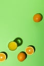 Top view of glass of orange juice, half and whole oranges on thegreen background.Empty space