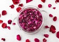 Top view of a glass pot with pink organic rose petals for making sweet syrup, alcoholic beverage, liquor or flower flavor wine. Royalty Free Stock Photo