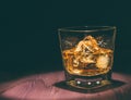 Top of view of glass of whiskey with ice cubes on wood table, warm atmosphere, time of relax with whisky Royalty Free Stock Photo