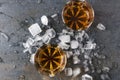 Top view of glasses with brandy and pieces of ice on gray surface.Party drinks Royalty Free Stock Photo