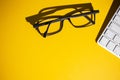 Top view of glasses and keyboard on a yellow work table Royalty Free Stock Photo