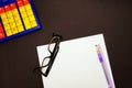 Top view of the glasses, on a white sheet. Black background. Bright colors calculator, purple pen and pencil. Business Royalty Free Stock Photo