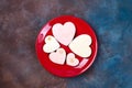 Top view of glazed heart shaped cookies on red plate on stone, flat lay. Happy Valentines Day