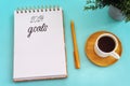 Top view 2024 goals list with notebook, cup of coffee on pastel background