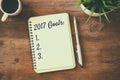 Top view 2017 goals list with notebook, cup of coffee