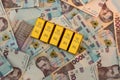 Top view of gold bars lying on a background of Ukrainian money. UAH. Save and money concept