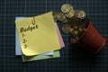 Top view of gold coins and a stack of memo notes written with Budget and list of number on a green square background