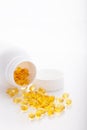 Top view of Gold fish oil scattered from pill bottle isolated for good health on white background. Supplementary food Royalty Free Stock Photo