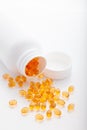 Top view of Gold fish oil scattered from pill bottle isolated for good health on white background. Supplementary food Royalty Free Stock Photo