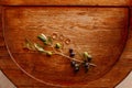 Top view of gold wedding rings and an engagement ring on brown wooden texture with a sprig of olive tree fruits. Royalty Free Stock Photo